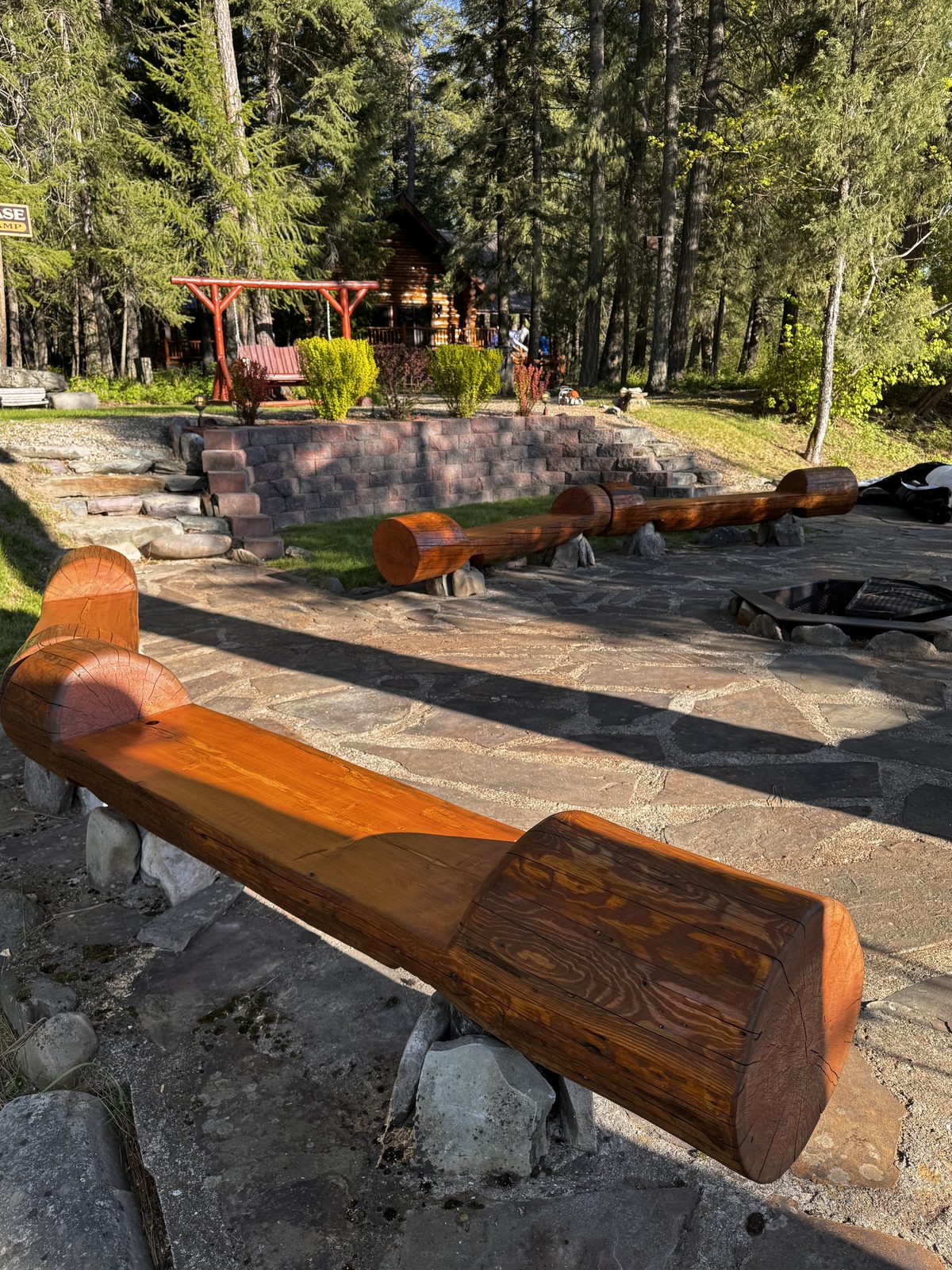 Custom carved log benches by fire pit, Troy MT